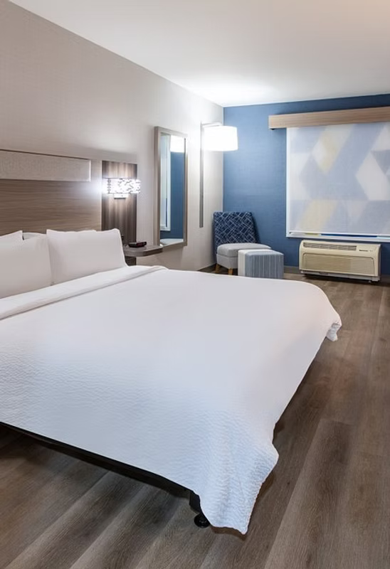 Modern bedroom with a large bed, nightstands, and a television.